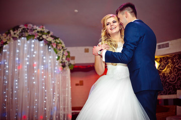 Romantic couple of newlyweds first elegant dance at wedding rece