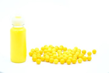 Vitamins in liquid form and vitamin tablets on a white background