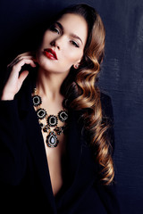 Obraz premium woman with dark curly hair, wears elegant clothes and bijou necklace