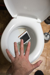 a man throws phone in toilet