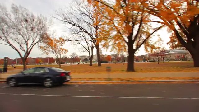 Tracking, wide shot of the United States Capitol building in autumn.