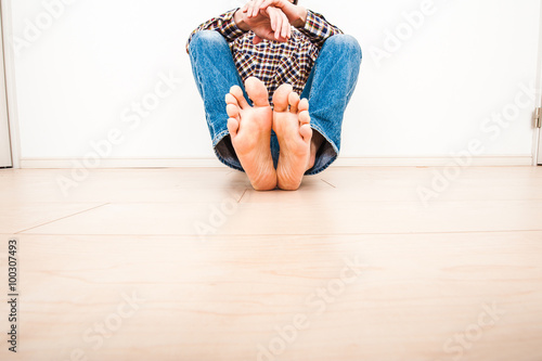 部屋の床に座ってリラックスしている男性 Wall Mural Beeboys