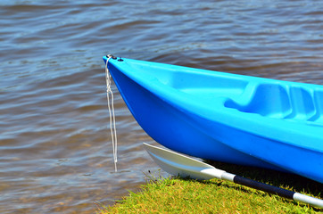 Fototapeta na wymiar Blue kayak on river bank