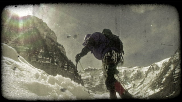 Mountain climber hikes toward sun 2. Vintage stylized video clip.