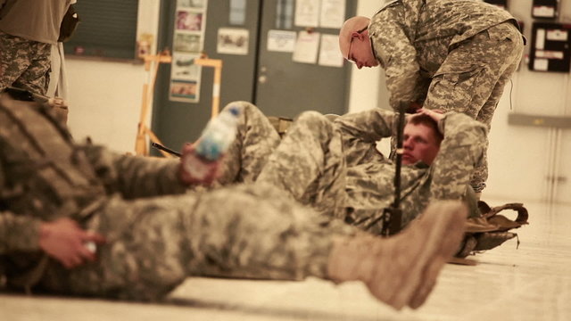 Shot coming into focus showing soldiers lying on the ground.