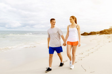 Runners. Young couple running on beach