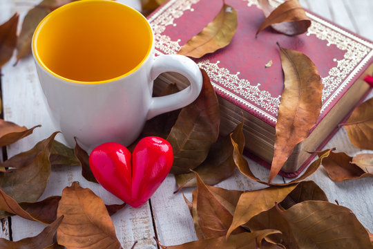 notebook and brown leaves with heart icon and coffee cup