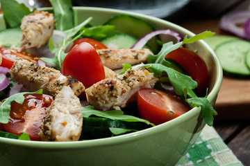 Fresh salad with chicken, tomatoes and arugula on plate