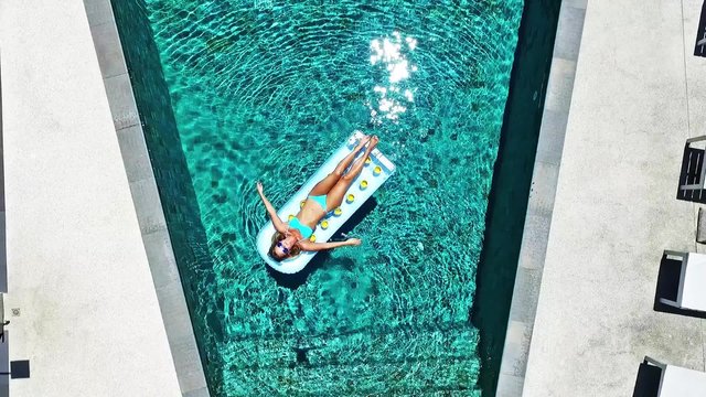 Young girl swims in the pool