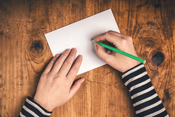 Woman writing recipient address on mailing envelope