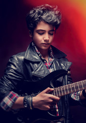 Fototapeta na wymiar Teen guy playing on guitar