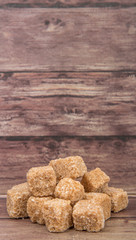 Brown sugarcane sugar cube over wooden background