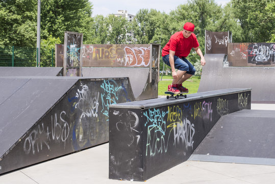 Skateboarder doing a jumping trick at skateboard park