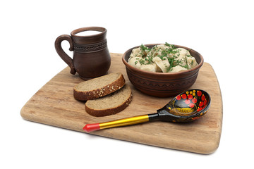 Russian cuisine: dumplings, cup of milk and bread on white backg
