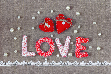 The word love with a hearts, pearls and lace on a background of