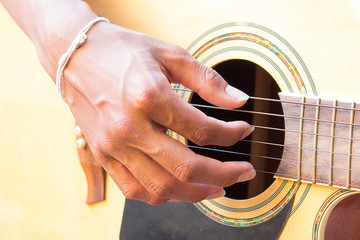 Guitarist hand playing acoustic guitar