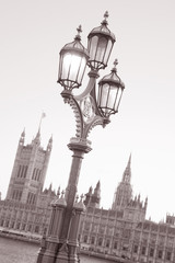 Fototapeta na wymiar Lamppost and Houses of Parliament, London, England, UK in Black and White Sepia Tone on Slanted Angle