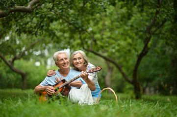 Mature couple with guitar   in park