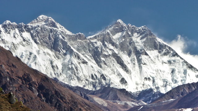 Time-lapse of Everest and surrounding peaks and people on a foreground trail. Cropped.