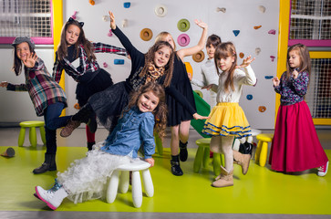 Fototapeta premium Group of happy preschoolers dancing in playroom