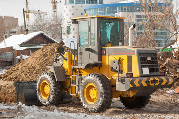 Fototapeta na wymiar Tractor removes debris from building demolition