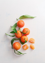 Sweet tangerines with leaves on table