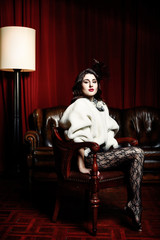 beautiful woman in evening cloth sitting in  victorian chair