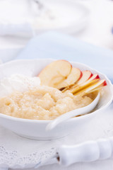 Apple puree dessert with cream and fresh apples in a white bowl on a white tea-tray. selective focus..
