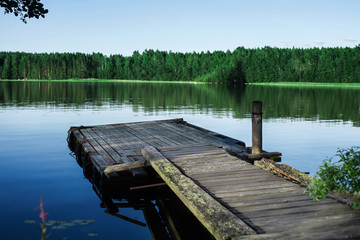Naklejka premium Old wooden pier on a lake at sunrise