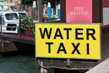 Fototapeta premium Yellow Water Taxi Sign in Venice, Italy