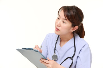 Japanese female doctor fills in clinical record