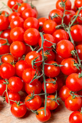 Fresh cherry tomatoes on wooden background
