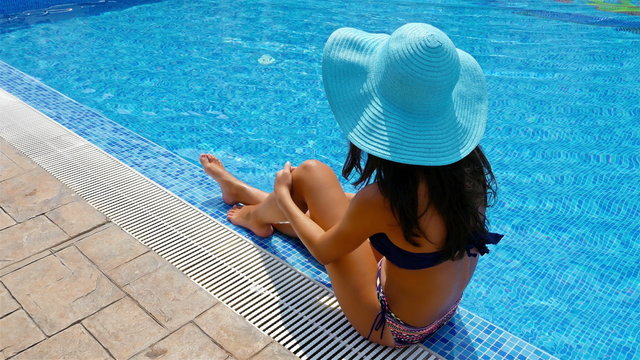 Young woman in swimming suit on the edge of a swimming pool