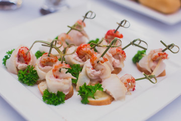 Beautifully decorated banquet catering prepared table with different food snacks and appetizers with sandwich, caviar, fresh fruits on corporate christmas birthday party event or wedding celebration 