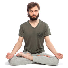 Young man with beard doing yoga on a white background