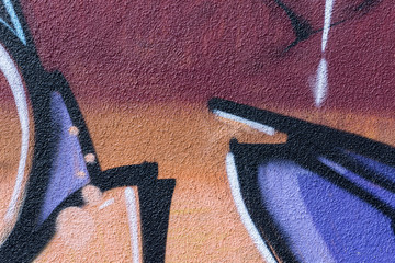 Detail of a graffiti art on a wall. Wall painted in different coolors. Abstract colorful background.
