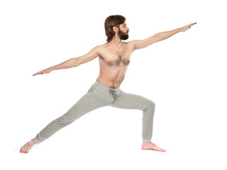 Young man with beard doing yoga on a white background