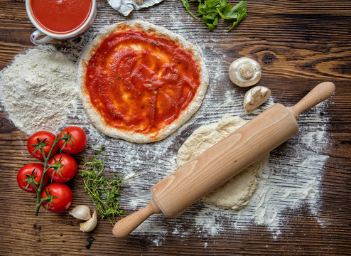 Pizza dough on rustic wooden table