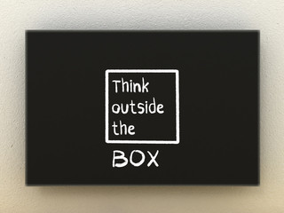 Think outside the box illustration on black board.