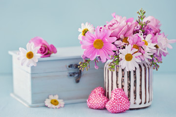 Daisy flowers and box with a gift on a blue background .