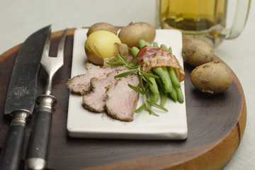 roasted lamb with beans in bacon and potatoes
