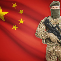 Fototapeta premium Soldier with machine gun and flag on background - China