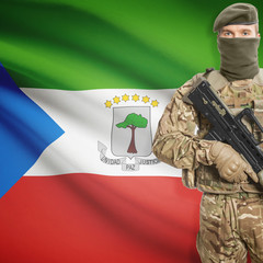 Fototapeta premium Soldier with machine gun and flag on background - Equatorial Guinea