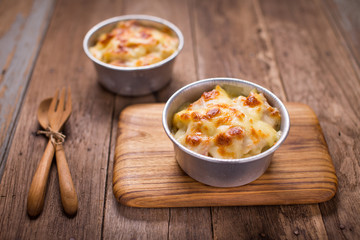 Au Gratin cheese pasta on the wood table.