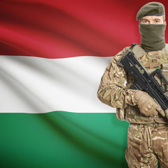 Soldier with machine gun and flag on background - Hungary