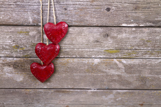 Valentine's day ornament on wood background. wooden two red hearts on old wooden gray background