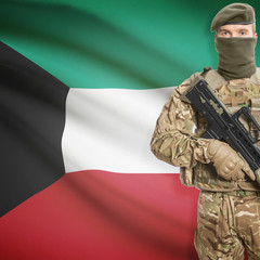 Fototapeta premium Soldier with machine gun and flag on background - Kuwait