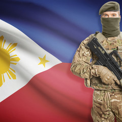Fototapeta premium Soldier with machine gun and flag on background - Philippines