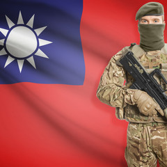 Fototapeta premium Soldier with machine gun and flag on background - Taiwan