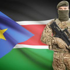 Fototapeta premium Soldier with machine gun and flag on background - South Sudan
